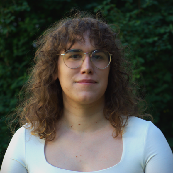 A picture of a brunette with glasses and a white top looking at the camera